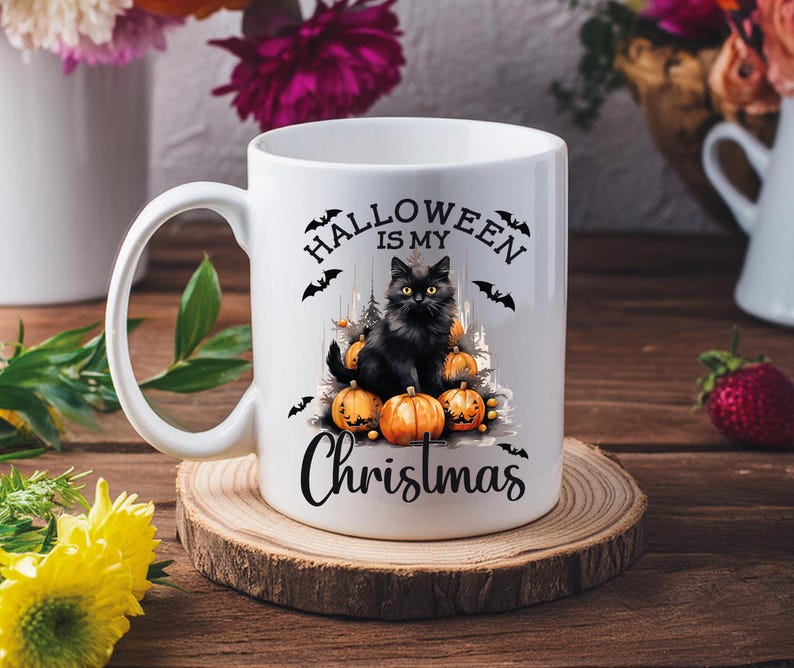 Puede incluir: Taza de cer&aacute;mica blanca con un gato negro sentado sobre una pila de calabazas. La taza tiene el texto "Halloween is my Christmas" impreso en ella.