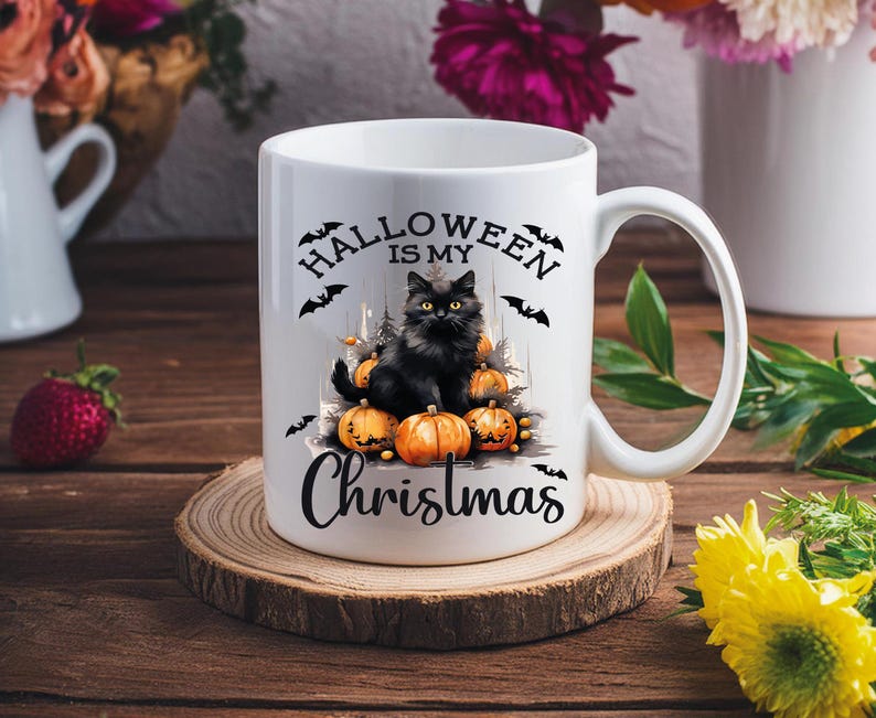 Puede incluir: Taza de cer&aacute;mica blanca con un gato negro sentado sobre una pila de calabazas naranjas. La taza tiene el texto "Halloween is my Christmas" impreso en ella.