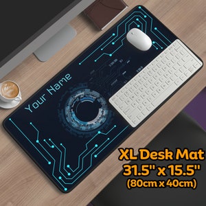 Op de afbeelding: Een zwarte en blauwe XL-bureauonderlegger met een print van een printplaat en de tekst "Your Name". De onderlegger is 31,5 inch bij 15,5 inch, of 80 centimeter bij 40 centimeter.