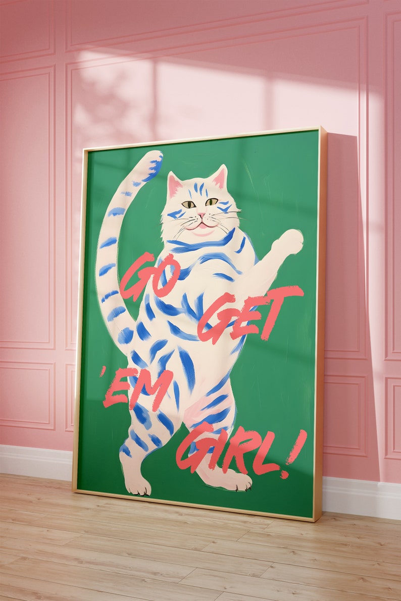 May include: A green canvas print with a white cat with blue stripes standing on its hind legs. The cat has a pink nose and a pink tongue. The text "GO GET 'EM GIRL!" is written in pink on the canvas.