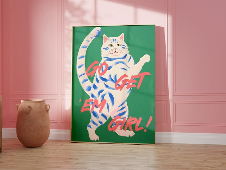 May include: A green poster with a white cat with blue stripes standing on its hind legs. The cat has a pink nose and pink paw pads. The text on the poster says "Go Get 'Em Girl!"