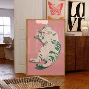 May include: A framed illustration of a white cat with green stripes, lying on its back with its paws in the air, on a pink background.