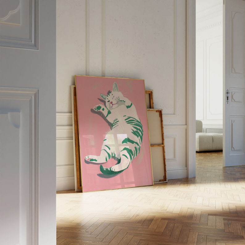 May include: A framed illustration of a white cat with green stripes on a pink background. The cat is lying on its back with its paws in the air.
