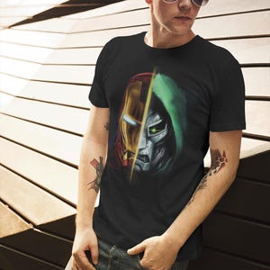 May include: A black t-shirt with a graphic print of Iron Man and Doctor Doom's faces, split down the middle. The graphic is in shades of red, yellow, green, and silver.