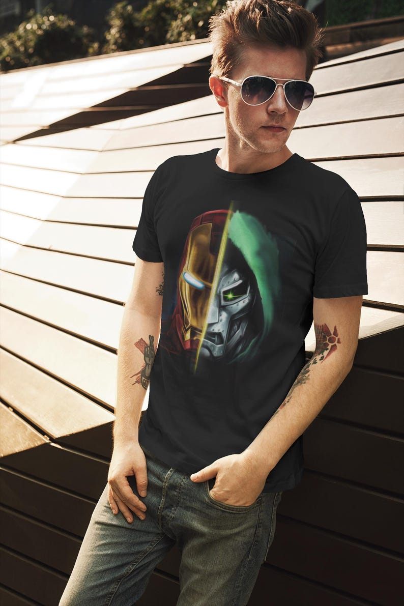 May include: A black t-shirt with a graphic print of Iron Man and Doctor Doom's faces, split down the middle. The graphic is in shades of red, yellow, green, and silver.