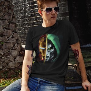 May include: A black t-shirt with a graphic of Iron Man and Doctor Doom's faces, split down the middle. The graphic is in red, yellow, green, and silver.