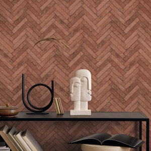 May include: A modern sculpture of two faces, one white and one gray, on a black shelf with books and a decorative bowl. The sculpture is in front of a wall with a brick pattern wallpaper.