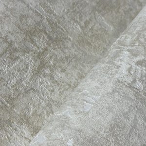 May include: Close-up of a textured, off-white wallpaper with a subtle, mottled pattern. The surface has a slightly raised, tactile quality, with variations in tone creating depth and visual interest. The wallpaper is rolled.