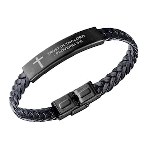 May include: Black leather bracelet with a black metal clasp and a black metal plate with the inscription "TRUST IN THE LORD - PROVERBS 3:5" and a cross.