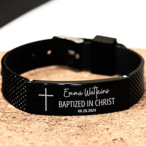 K&ouml;nnte beinhalten: Schwarzes Armband mit einer silbernen Metallplatte, die mit einem Kreuz, dem Namen "Emma Watkins", dem Text "Getauft in Christus" und dem Datum "08.20.2024" graviert ist.