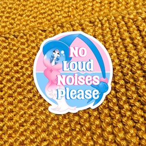 May include: A pink and blue sticker with a cartoon character and the text "NO LOUD NOISES PLEASE".