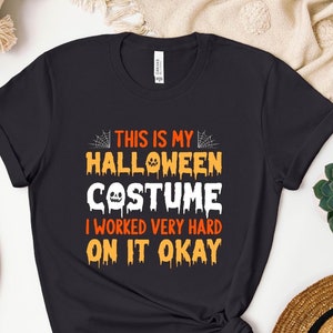 May include: Black t-shirt with orange and white text that reads "This is my Halloween Costume I worked very hard on it okay".