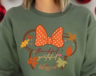 Puede incluir: Sudadera verde con un lazo blanco y naranja con lunares, rodeado de hojas de otoño y el texto "thankful grateful blessed".