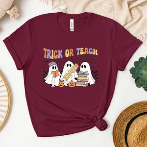 a t - shirt that says trick of teach with two ghost reading a book