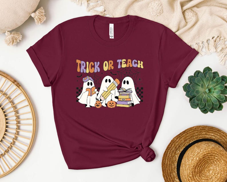 a t - shirt that says trick of teach with two ghost reading a book