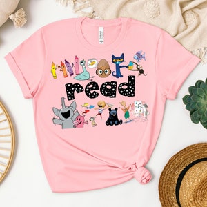 May include: Pink t-shirt with a graphic of children's book characters and the text "Let's read".