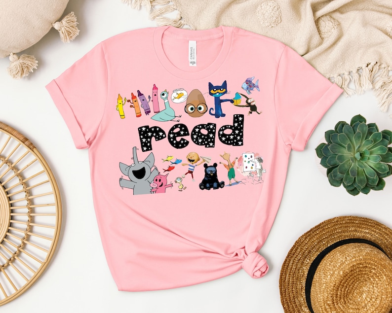 May include: Pink t-shirt with a graphic of children's book characters and the text "Let's read".