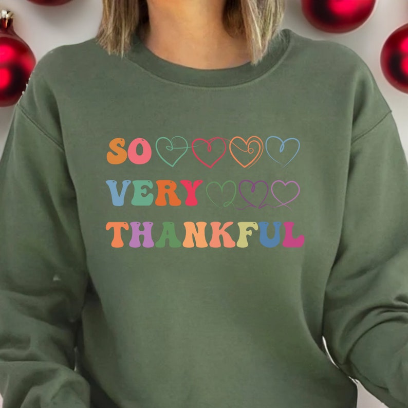 May include: Green sweatshirt with the text "SO VERY THANKFUL" in rainbow colors with hearts between each word.