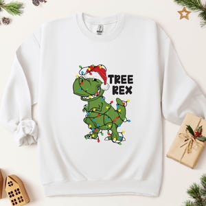 a t - shirt with a dinosaur wearing a christmas hat