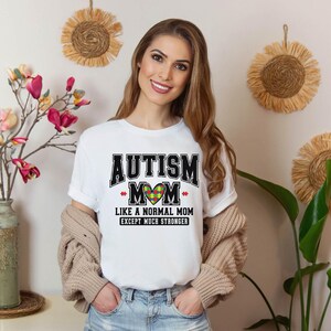 a woman wearing a t - shirt that says autism mom