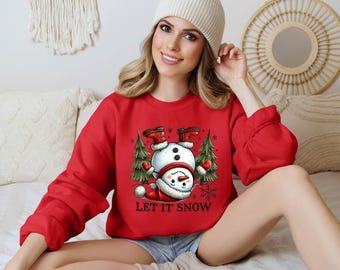May include: Red Christmas sweatshirt with a snowman wearing a Santa hat and the text "Let It Snow".