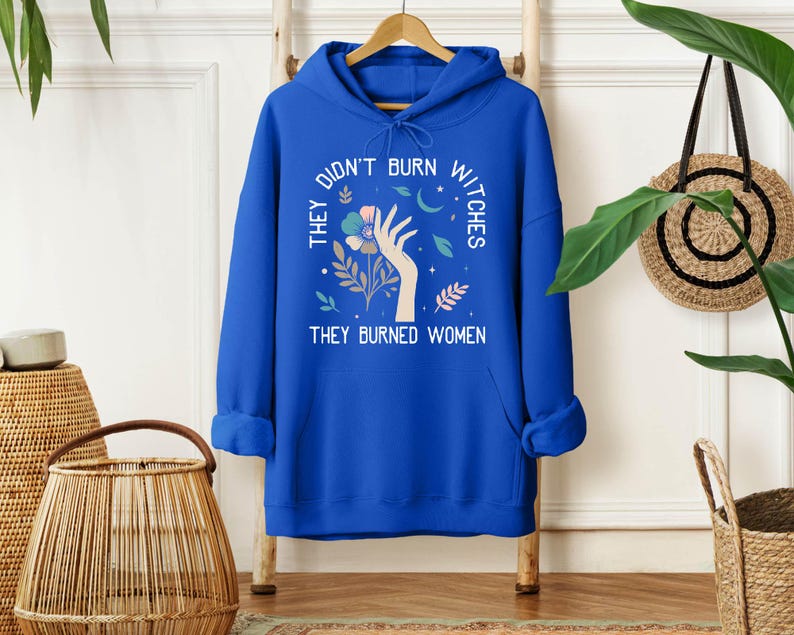 a blue hoodie that says they don't burn nices they buried women
