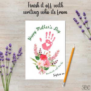 K&ouml;nnte beinhalten: Ein rosa Handabdruck mit einem Herz in der Mitte ist von einem Blumenkranz umgeben. Der Text "Happy Mother's Day" ist in gr&uuml;ner Schrift &uuml;ber dem Handabdruck geschrieben. Der Text "Handmade with love by Sophia xo" ist unter dem Handabdruck geschrieben.
