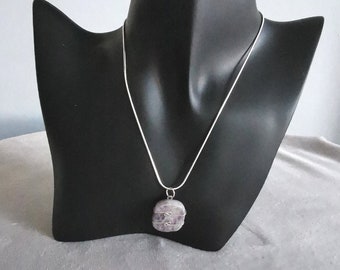 May include: A silver chain necklace with a pendant made from a light purple stone wrapped in silver wire.