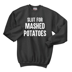 Puede incluir: Una sudadera gris oscuro con el texto "SLUT FOR MASHED POTATOES" impreso en blanco.