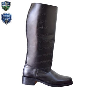 May include: A tall, black leather riding boot. The boot features a smooth, polished finish and a rectangular patch near the top. The sole is a darker shade of black. The boot is designed for equestrian activities.