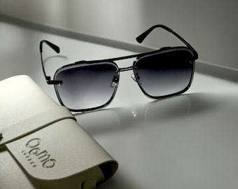 May include: Black sunglasses with a gradient lens and a black leather case with the word "Gemio" embossed on it.