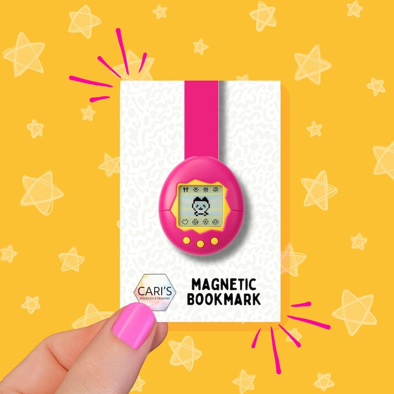 May include: A pink magnetic bookmark with a retro digital pet design. The bookmark has a pink strap and a yellow screen displaying a pixelated character. The text "MAGNETIC BOOKMARK" is visible.