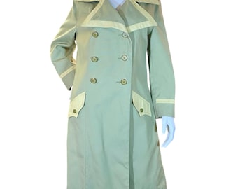 May include: A light green double-breasted trench coat with cream-colored trim on the collar, pockets, and cuffs. The coat has six gold-colored buttons and a classic design, suitable for various occasions.