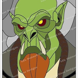 May include: Stained glass design featuring a green goblin-like creature with large ears, a prominent nose, and sharp teeth. The creature has red eyes with yellow pupils and brown horns. The design is framed by gray and tan glass.