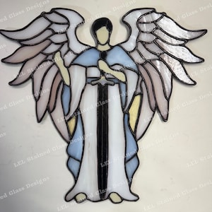 May include: Stained glass angel with outstretched wings, holding a sword. The angel's robe is white and blue, with accents of yellow and pink. The wings are multi-layered with a variety of colors. The image has the text "LEL Stained Glass Designs".