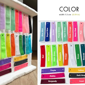 May include: A display of fabric swatches in various colors, each 0.59 inches wide, including red, blue, green, and pink. The swatches are pinned to a white display board, with color names labeled.