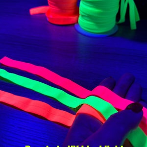 May include: Neon orange and green spools of ribbon are displayed, along with neon pink, green, and orange ribbons. The text "Reacts to UV blacklight" and color names are included.