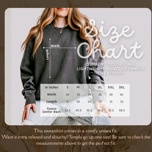 May include: A size chart for a Comfort Colors 1466 lightweight adult crewneck sweatshirt. The chart shows measurements in inches for width, length, and sleeve center back, ranging from size S to 3XL. The sweatshirt is shown in a dark gray color.