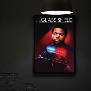 May include: A poster for the TV show "The Glass Shield" featuring a black man with a beard in a police uniform. The poster has a red background with a police car in the foreground.