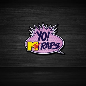 Puede incluir: Un globo de diálogo de estilo cómic rosa y azul con el texto "YO! MTV RAPS" en letras blancas y amarillas.