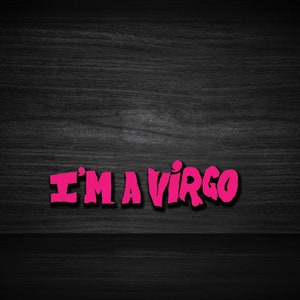 May include: Pink text on a black wood background that reads "I'M A VIRGO".