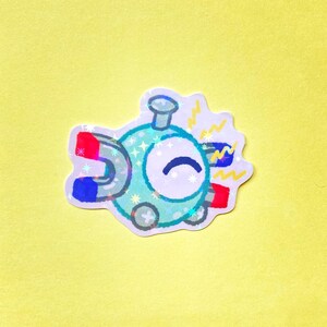 May include: A holographic sticker featuring a round, light blue character with a single eye, a small top protrusion, and two horseshoe magnets attached to its sides. The magnets have red and blue tips, and yellow lightning bolt icons surround them.