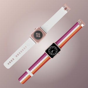 Peut inclure: Deux bracelets pour Apple Watch, l'un blanc et l'autre avec un motif de drapeau de la fierté lesbienne. Les deux bracelets ont des accents en or rose.