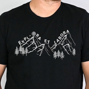 May include: Black t-shirt with a white mountain range graphic and the text "Explora Et Labora".