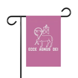 May include: A pink garden flag with a white outline of a lamb carrying a cross and a halo. The text "ECCE AGNUS DEI" is printed below the lamb.