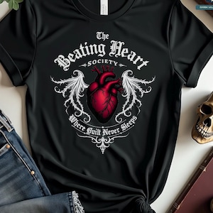 May include: Black t-shirt with a graphic design of a red heart with wings and the text "The Beating Heart Society Where Guilt Never Sleeps".