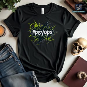 May include: Black t-shirt with a green and white graphic design featuring the text "#PSYOPS" in a bold, white font.