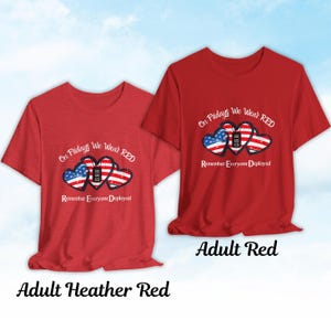 Może przedstawiać: Dwie czerwone koszulki z napisem "On Fridays We Wear RED" nad trzema kształtami serca w kolorach amerykańskiej flagi. Tekst "Remember Everyone Deployed" znajduje się pod sercami. Jedna koszulka jest oznaczona jako "Adult Heather Red", a druga jako "Adult Red".