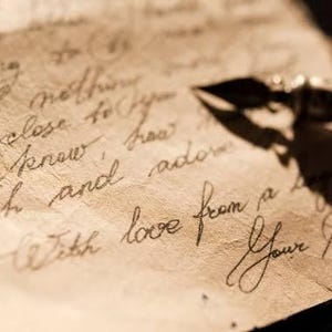 K&ouml;nnte beinhalten: Eine Nahaufnahme eines handgeschriebenen Briefes mit einem F&uuml;llfederhalter darauf. Der Brief lautet "be close to know how with and adore love from a heart your".