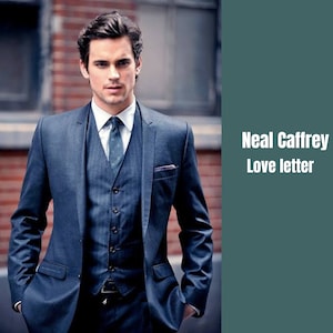 Op de afbeelding: Een man in een donkerblauw pak met een wit overhemd en een gepatenteerde stropdas. Hij staat voor een bakstenen muur. De tekst "Neal Caffrey Love letter" is zichtbaar aan de rechterkant van de afbeelding.